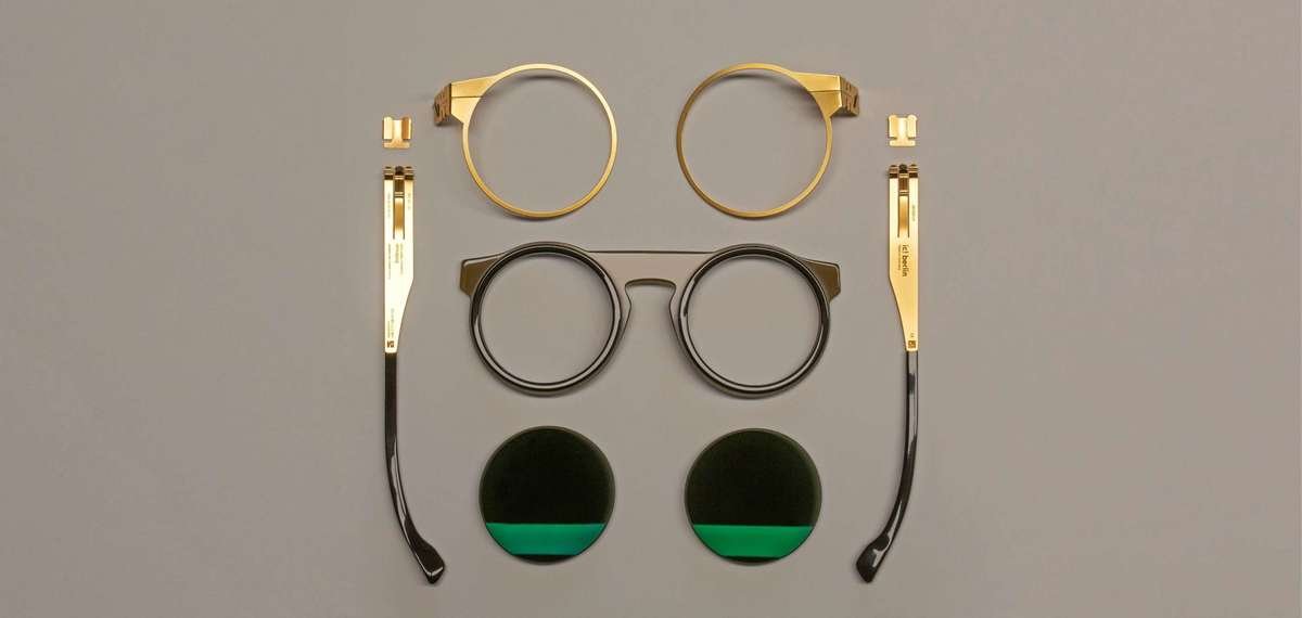 alkatrészeire szerelt fém szemüvegkeret barn háttér előtt zöld szemüveglencsékkel